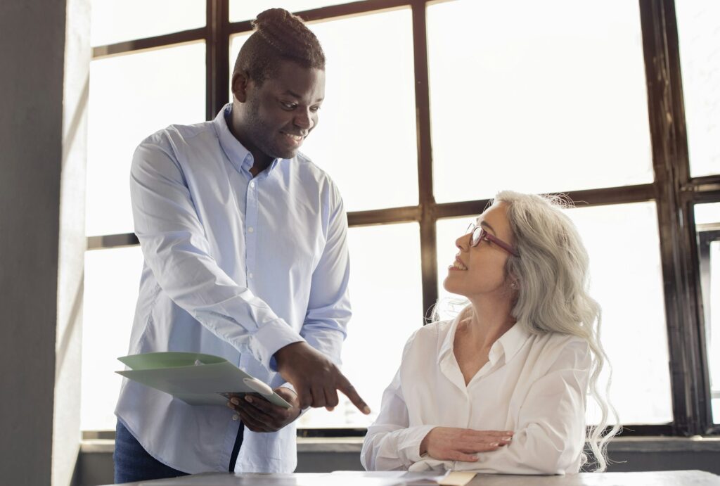 African American Businessman Providing Guidance to Employee Woman In Office