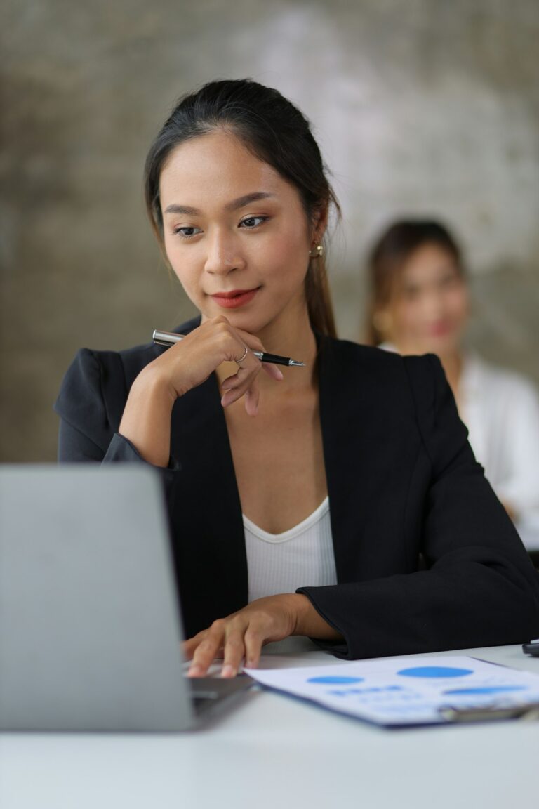 Attractive beautiful Asian business woman working on laptop on desk in office.