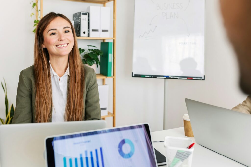 Cheerful businesswoman discussing with colleague in the office.